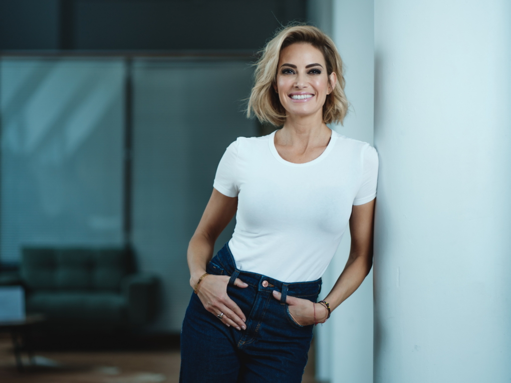 Sarah Valentina Winkhaus, Journalistin, Moderatorin, Autorin und Single Mom by Choice, lehnt lächelnd an einer Wand
